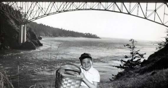 Dept. of Commerce and Economic Development
A boy with a picnic basket is photographed in front of Deception Pass Bridge in 1950.