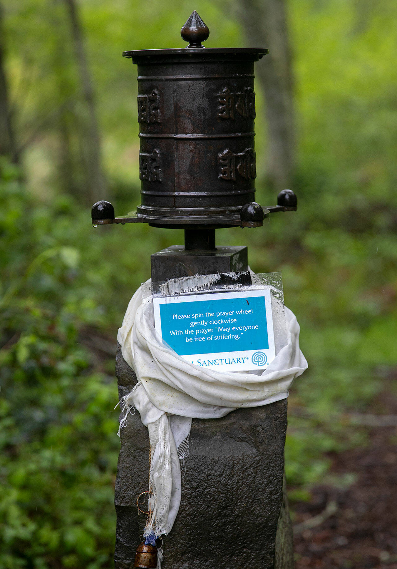 A prayer wheel is seen along the path at Earth Sanctuary. (Ryan Berry / The Herald)