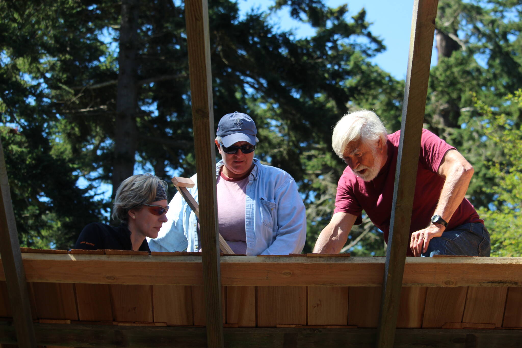 Harrison Goodall, right, works with volunteers on the restoration of the Pratt Machine Shed. (Photo by Karina Andrew/Whidbey News-Times)