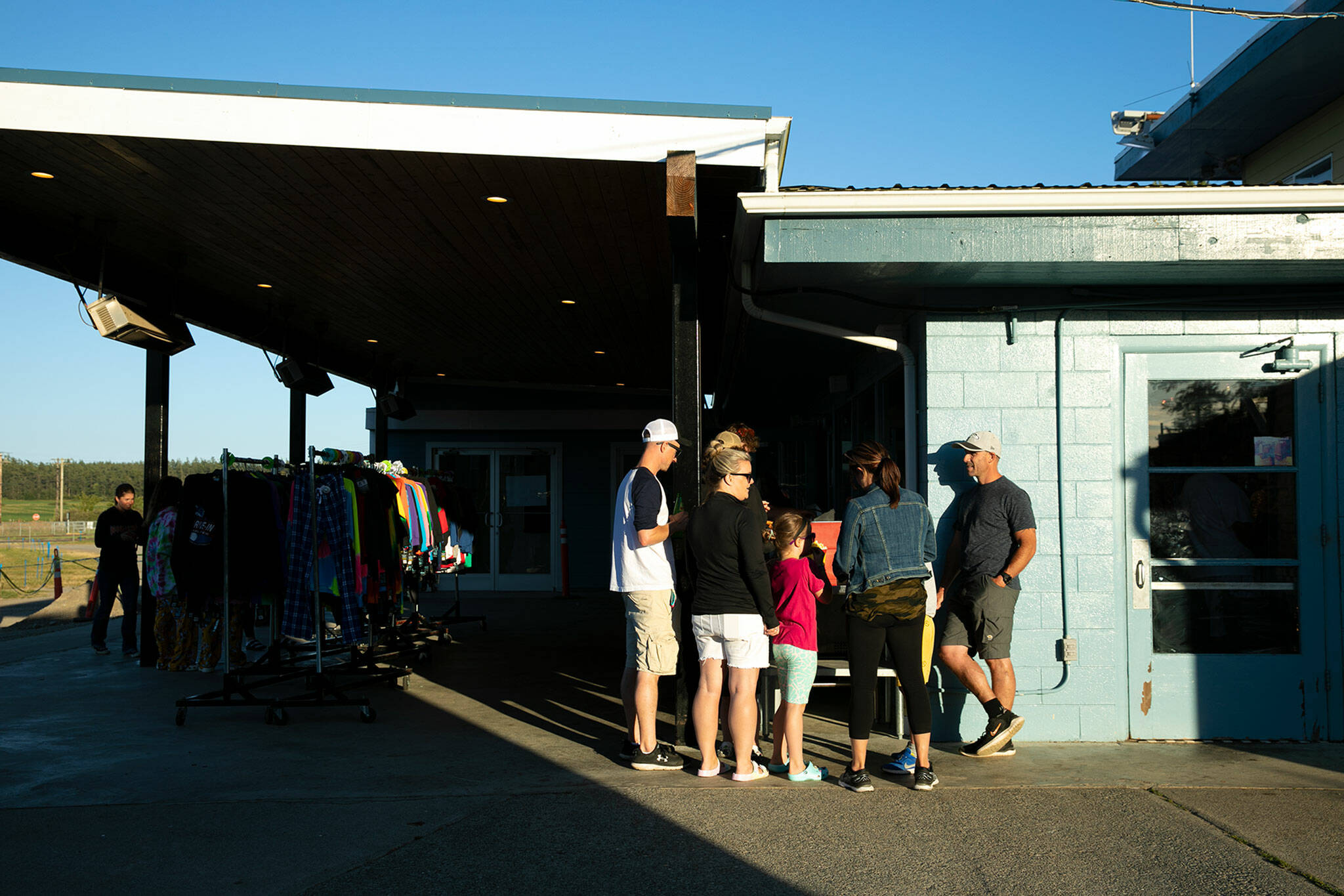 People gather before the playing of a movie at the Blue Fox Drive-In Theater in Oak Harbor. (Ryan Berry / The Herald)