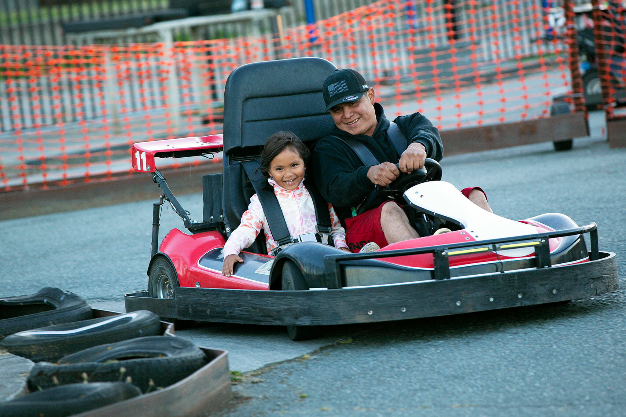 Angelina Jimmy, 6, and Brandon Cayou drive together in a go-kart at the Blue Fox Drive-In Theater in Oak Harbor. (Ryan Berry / The Herald)
