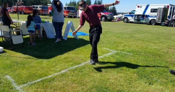 A participant wearing fatal vision goggles attempts to walk in a straight line at last year's National Night Out. (Photo provided by Oak Harbor Police Department)