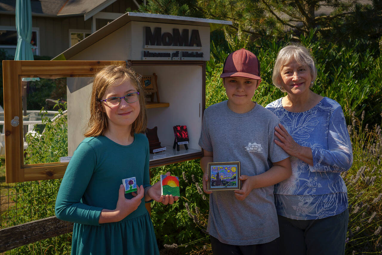 Photo by David Welton
Greta, 10, and Carl Kohlhaas, 12, with their artwork and grandmother Linda DiRienzo beside the Langley Museum of Mini-Art.