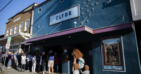 People line up on First Street for the doors to open at The Clyde Theater in Langley on Whidbey Island. The movie house opened in 1937. (Olivia Vanni / The Herald)