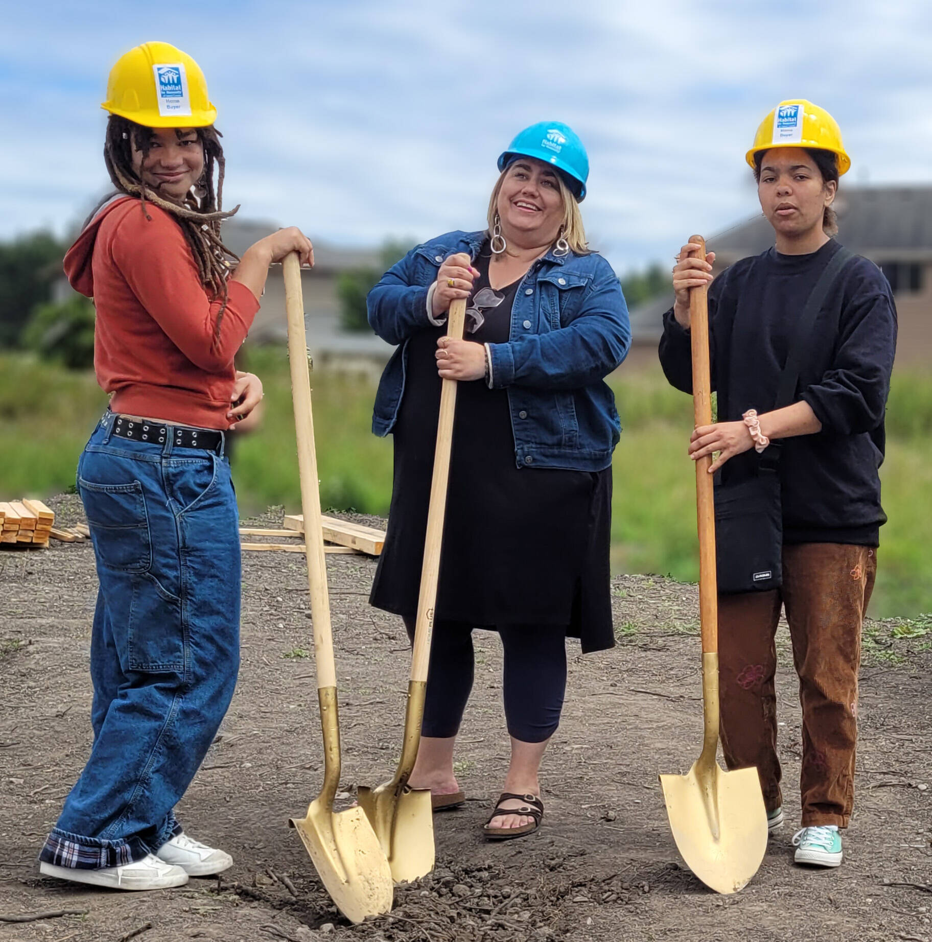 Habitat Homeowner Program participant Annie R., center, and her two daughters break ground at the site of their future home.