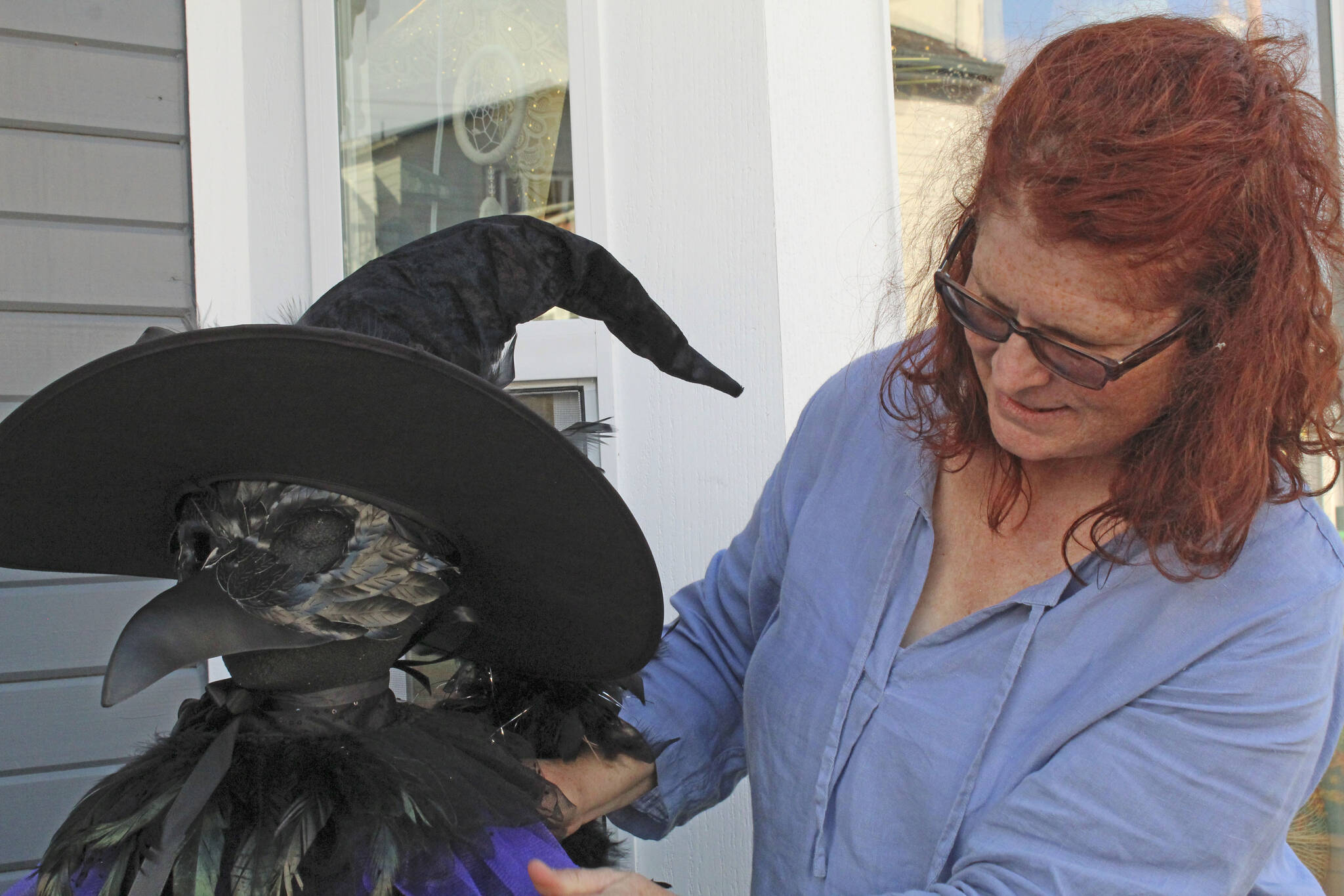 Photos by Karina Andrew/Whidbey News-Times
Mel Rodman makes some adjustments to the human-sized crow that represents her business, Crow’s Roost, in her Scarecrow Trail display.