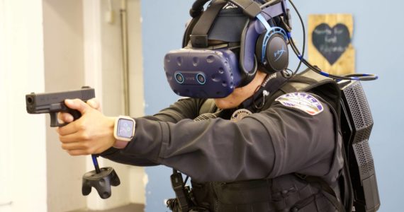 Photo by Rachel Rosen/Whidbey News-Times
Officer Shantel Ricci experiences a training scenario in the virtual reality world. She wears a headset connected to a backpack and carries a fake firearm.