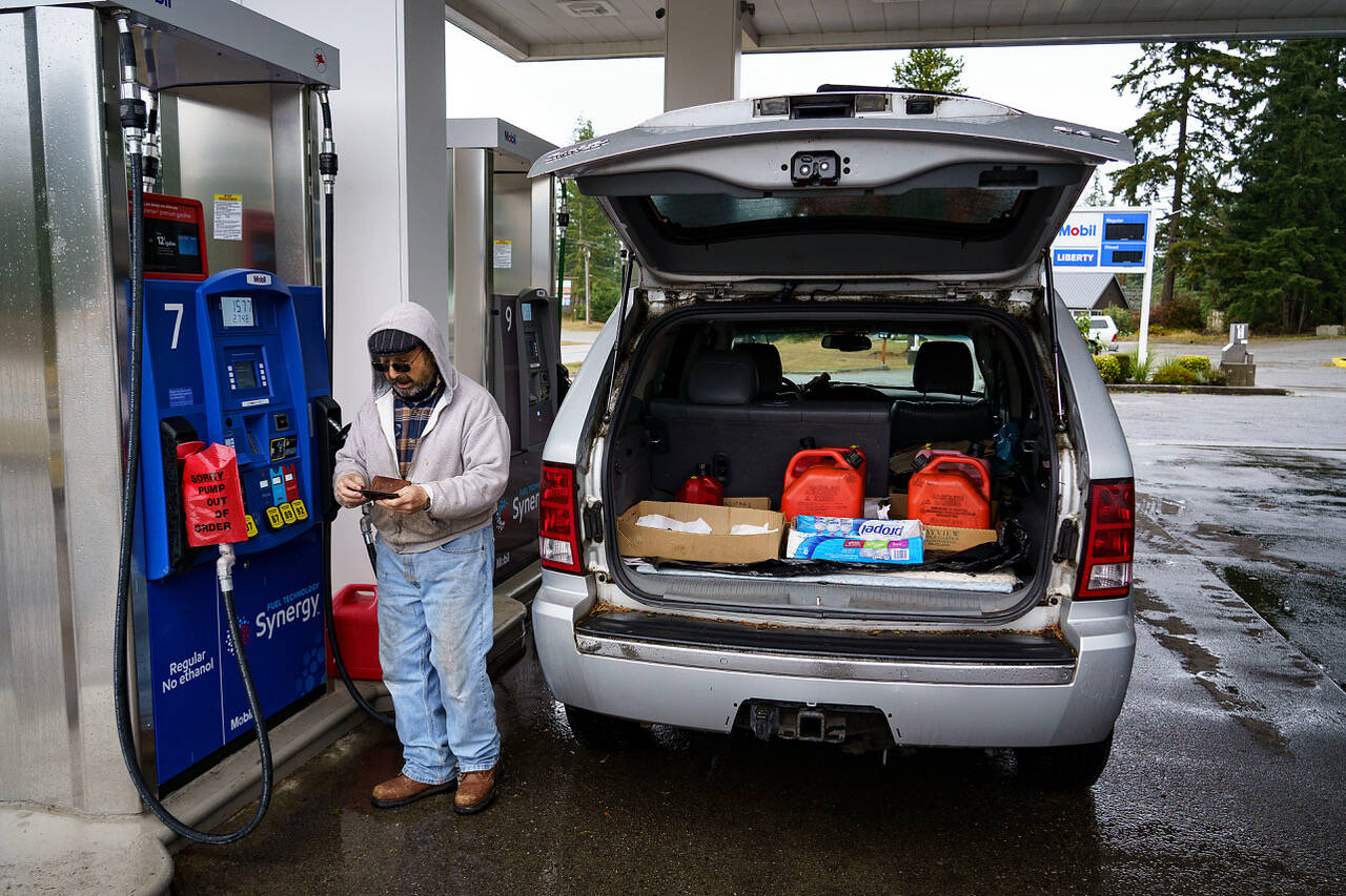 Photo by David Welton
Alfredo Herrera fills gas cans for his generator during power outages over the weekend.
