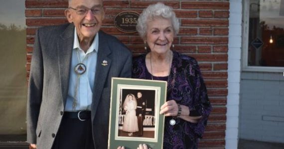 Eugene “Dud” Gilbert and Dorothy Gilbert pose for a photo just steps away from where they first met in downtown Oak Harbor 70 years ago. Photo by Emily Gilbert