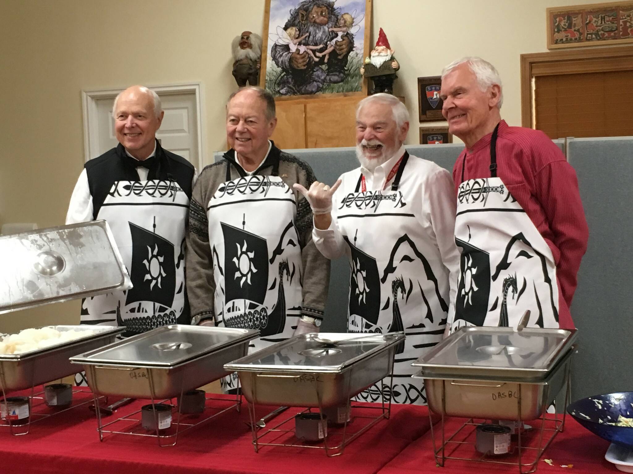 From left, Loran Haworth, Dick Johnson, Pete Berg and Bob Fordserve Lutefisk at the Whidbey Nordic Lodge’s 2019 dinner. (Photo provided)