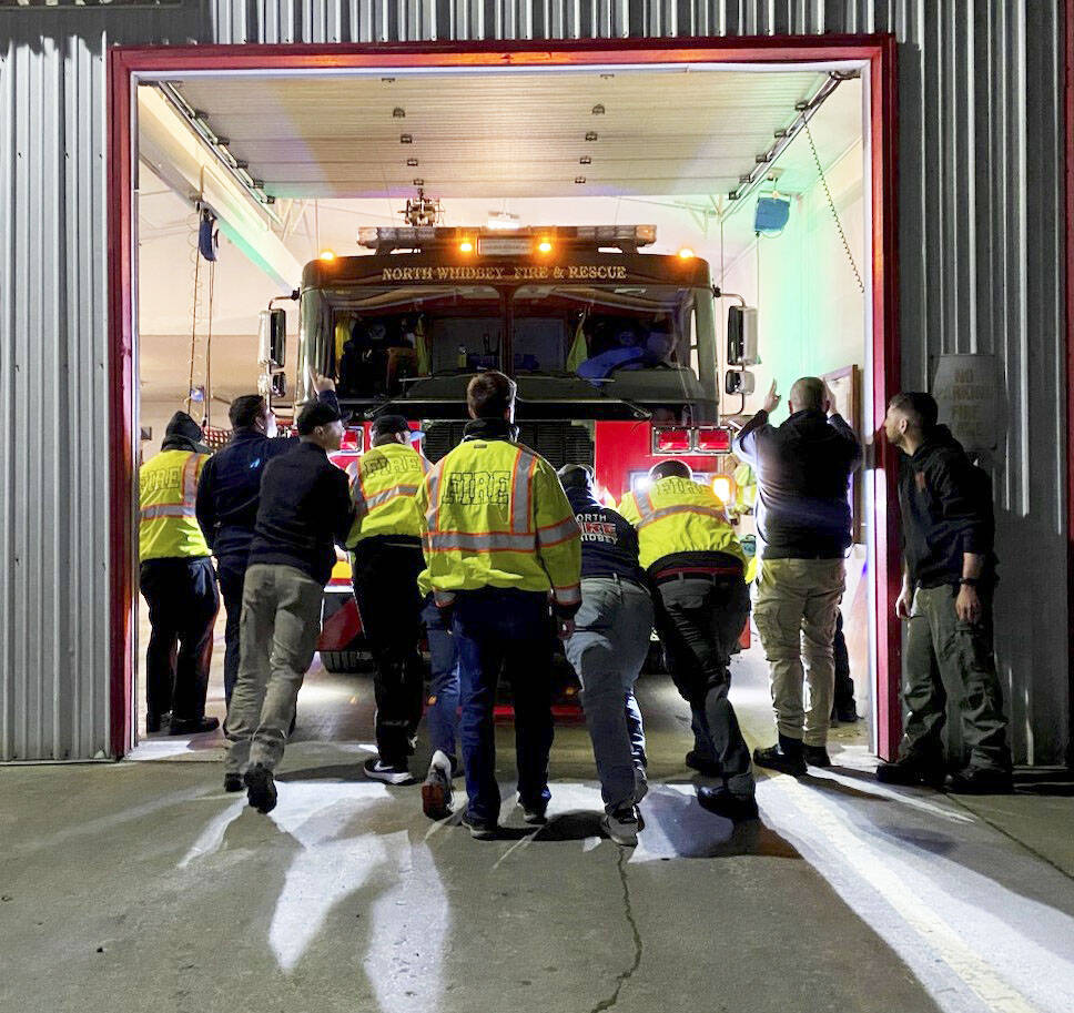 Photo provided
North Whidbey Fire and Rescue firefighters push one of two new engines into its new home at Station 25.
