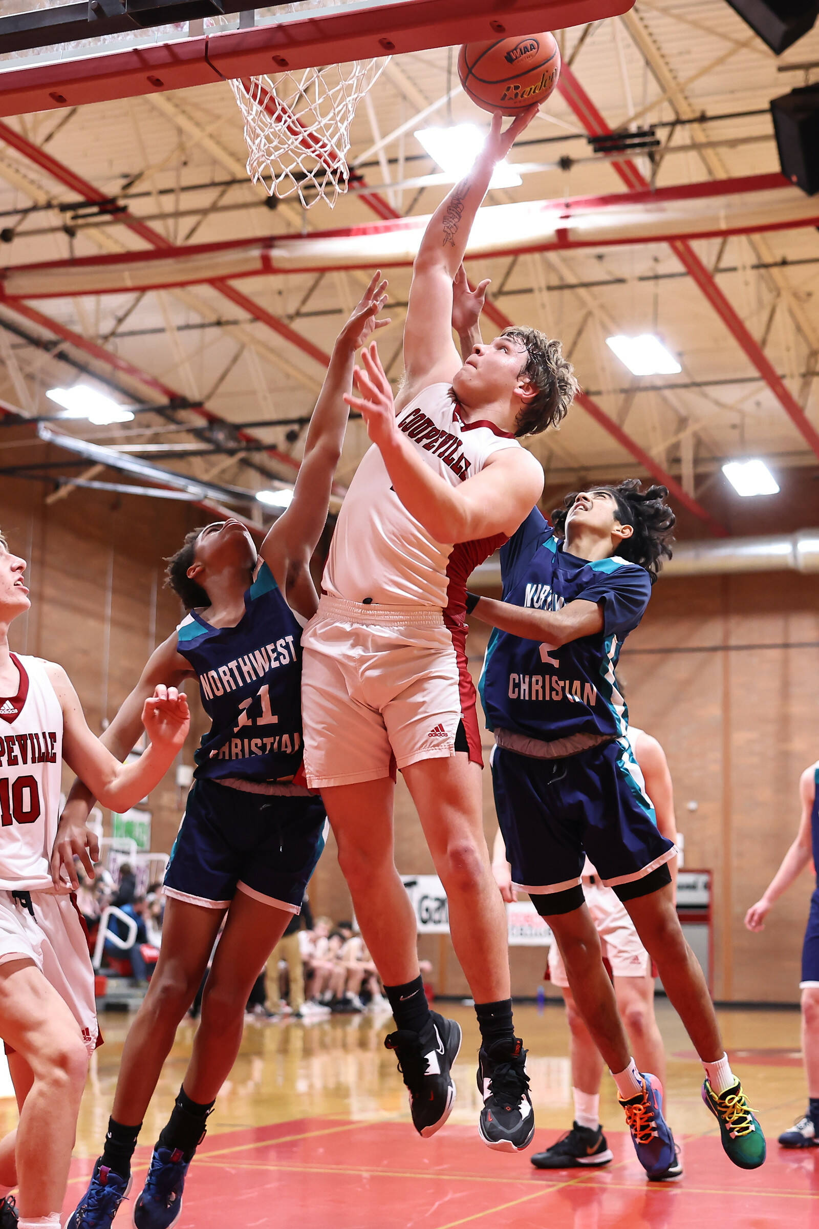 Coupeville High School senior Dominic Coffman takes a shot in a game against Northwest Christian on Tuesday. Coupeville hosted the bi-district tournament this week. For the boys, the tournament is a double elimination event. The Wolves beat Northwest Christian 64-26 Tuesday, then lost to La Conner 63-61 on Thursday. On Saturday, Coupeville will play Auburn Adventist in a winner-to-state, loser-out game. (Photo by John Fisken)