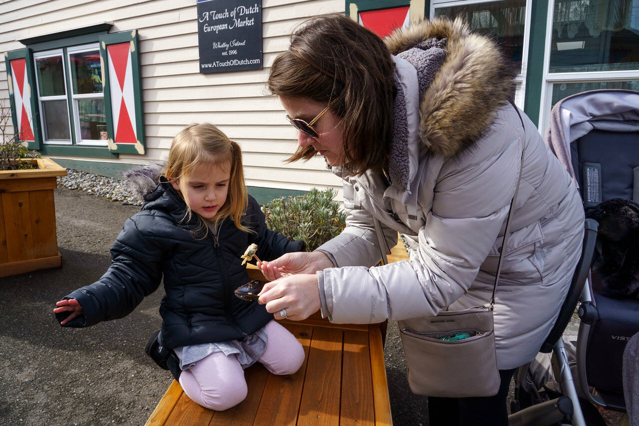McKenzie Peters coaxes her daughter to try a mussel.
