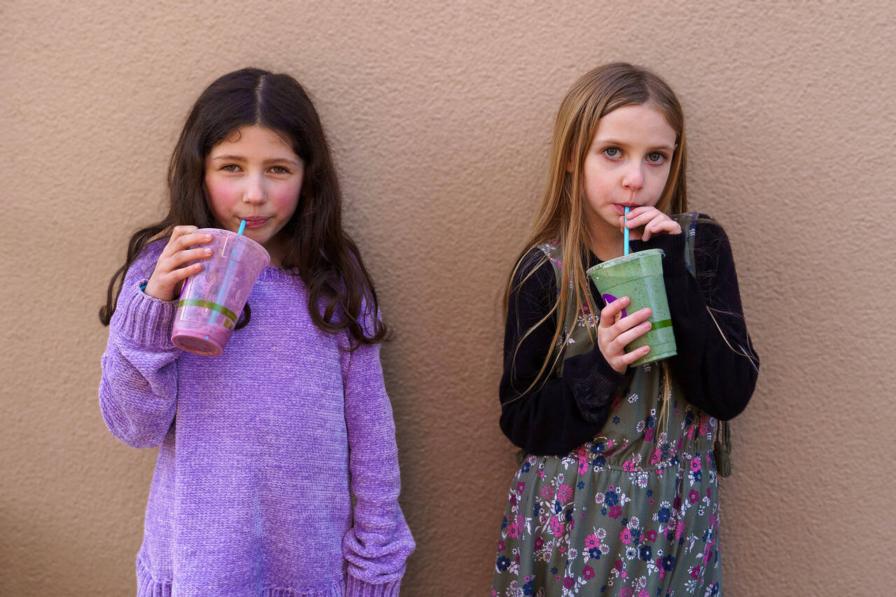 Willow Skaggs, 7, and Sapphire Simms Lamar, 8, sip drinks from TONIC Juice & Remedy.