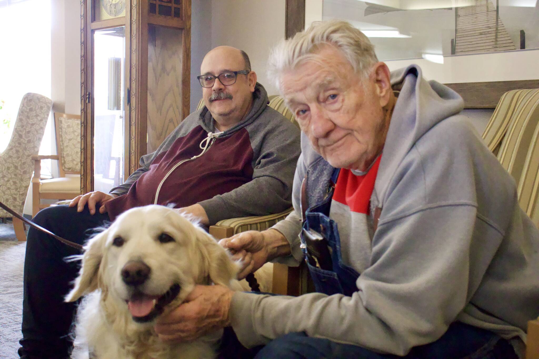 From left, Phill Neff and Gerald Henrich meet therapy dog Falkor.