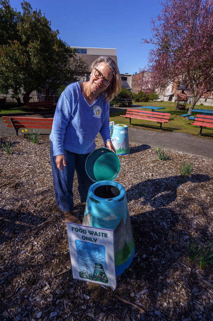 Joan Green, a member of rePurpose, demonstrates how to use a new composting bin at the South Whidbey Community Center. (Photo by David Welton)