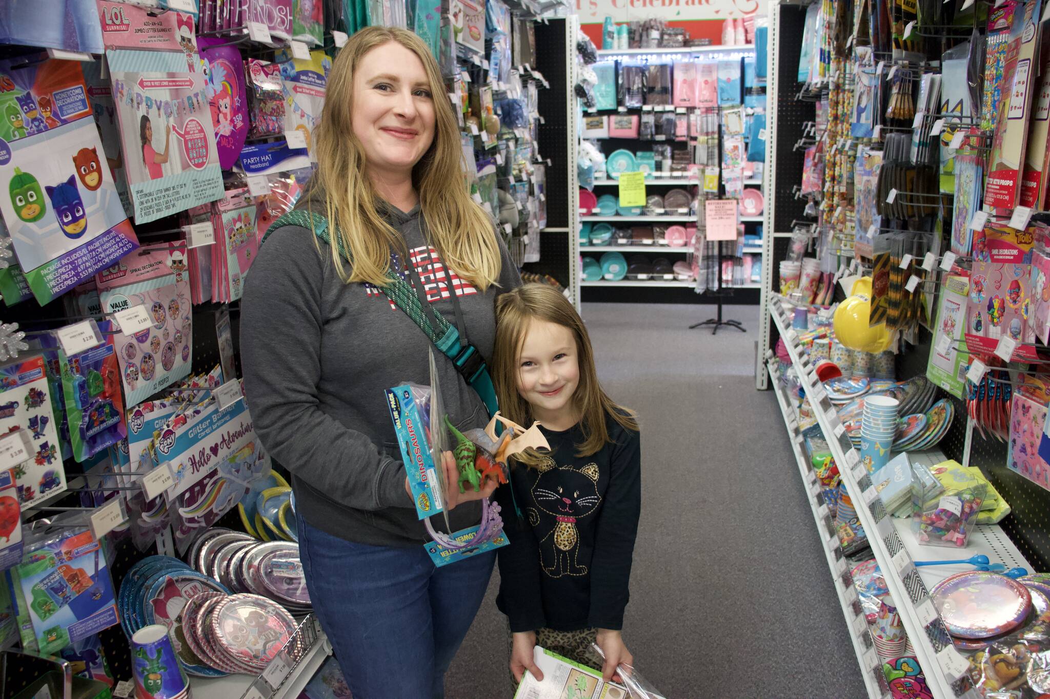 From left, Kayla and Avery Etheridge shop for dinosaur-themed birthday goodies at Whidbey Party Store. (Photo by Rachel Rosen/Whidbey News-Times)