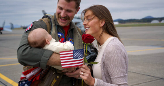 Photo by David Welton
Scott Waitley greets his wife, Maggie, and 2-month-old son, Warren, after returning home from deployment Saturday.