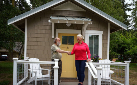 Photos by David Welton
Bon Thayer, THiNC site manager, and Deborah Hedlund, a member of the organization’s board, shake hands at the completion of the tiny house project.