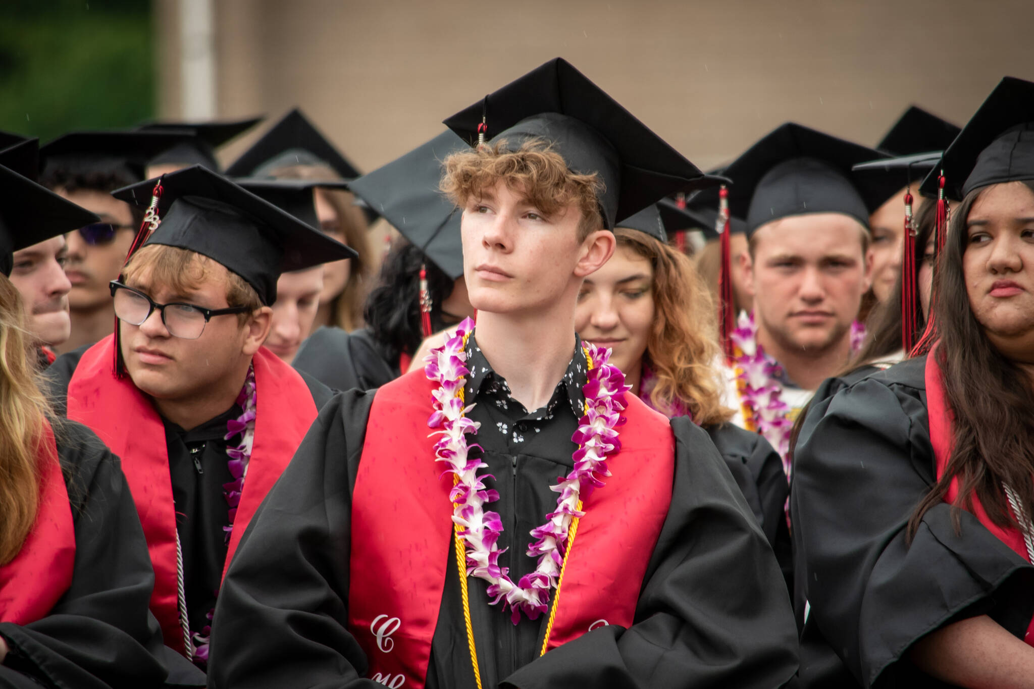 Connor Bachmann, center, and his fellow Coupeville seniors listen to presentations during Saturdays bittersweet high school graduation. (Cynthia Woerner Photography)