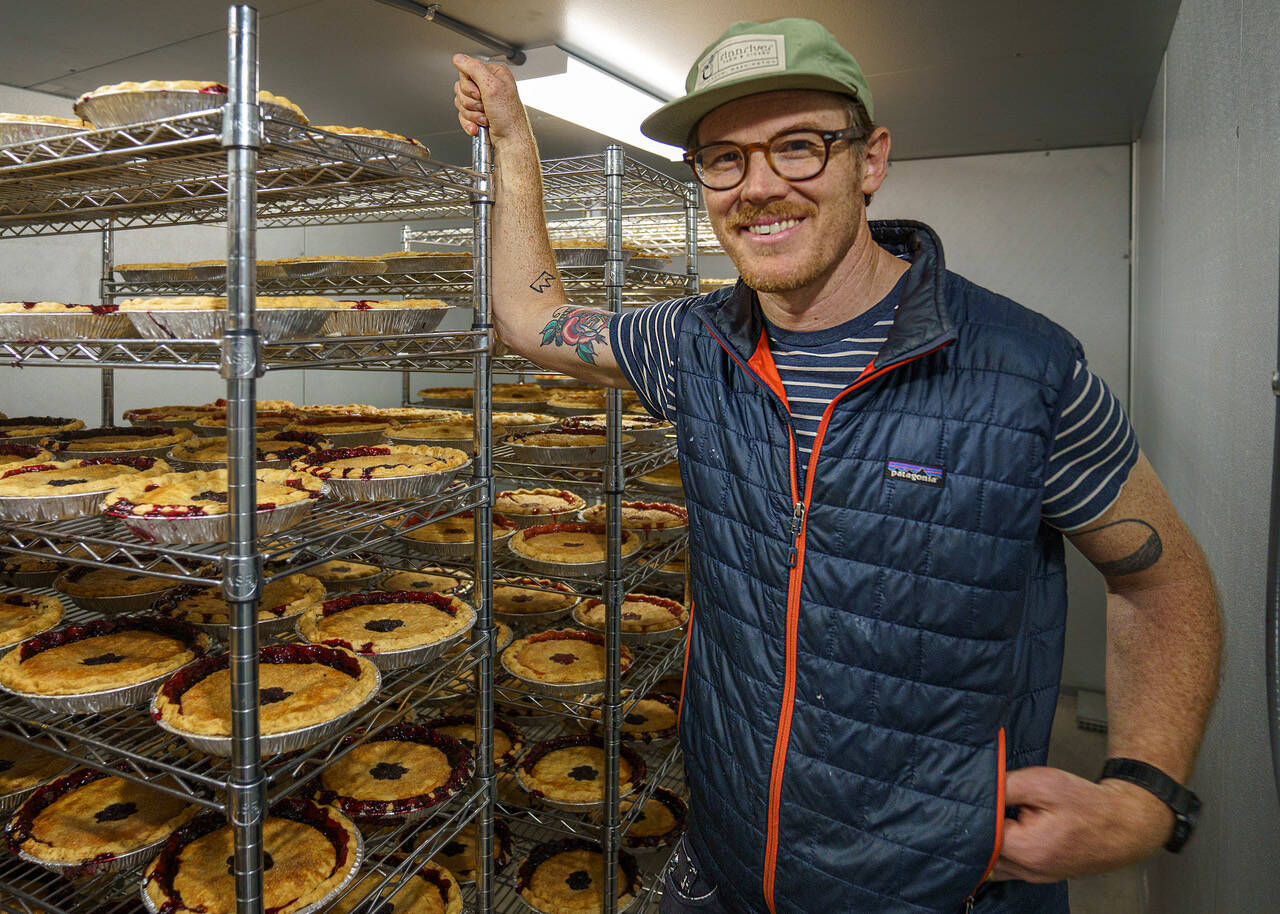 Joe Gunn with a rack of freshly baked pies in the cooling room of the Whidbey Pies production facility. (Photo by David Welton)