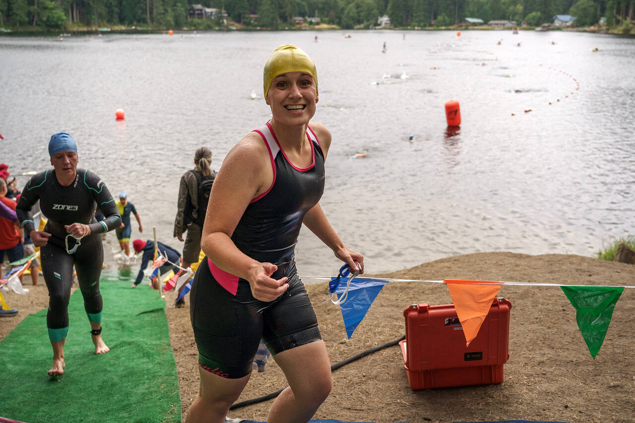 Whidbey News Group reporter Karina Andrew runs from Goss Lake after completing the first leg of the Whidbey Island Triathlon July 22. (Photo by David Welton)