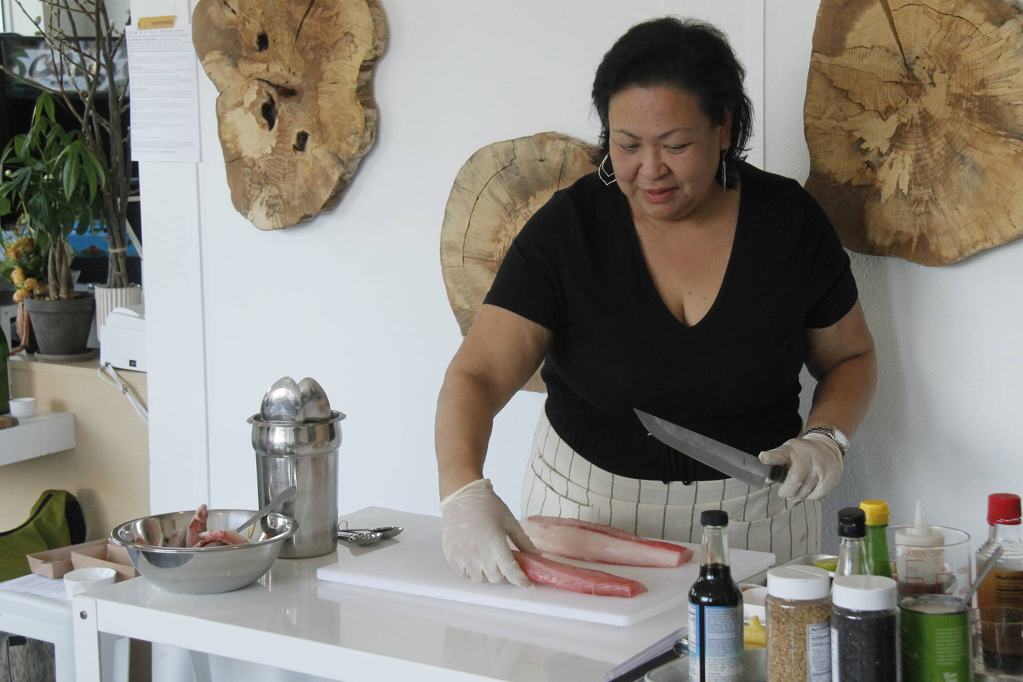 Joan Samson, owner of Mommafish, uses a left-handed Yanagi knife to cut fish during a recent supper club event at her restaurant in Langley. (Photo by Kira Erickson/South Whidbey Record)