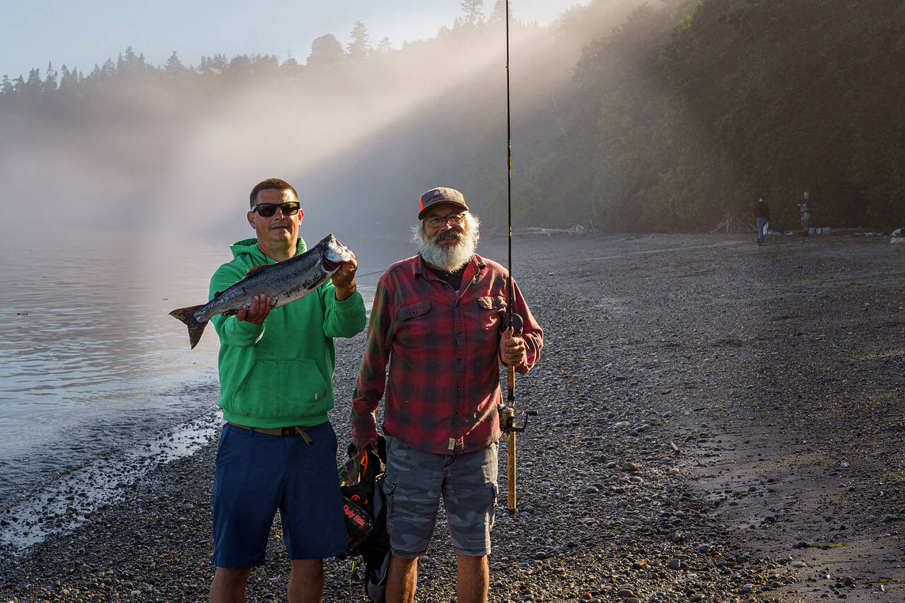 Roland Gobel has success while fishing for salmon at Bush Point with his father Kelly, who is visiting from California. (Photo by David Welton)