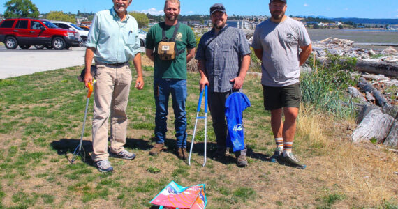 Photo by Luisa Loi/Whidbey News-Times
(From left to right) Darwin Christopherson, Washington Department of Fish and Wildlife Biologist Kurt Licence, WDFW Waterfrowl Section Manager Kyle Spragens and Peter Steelquist pose with the wads they collected at Windjammer Park on Aug. 2.