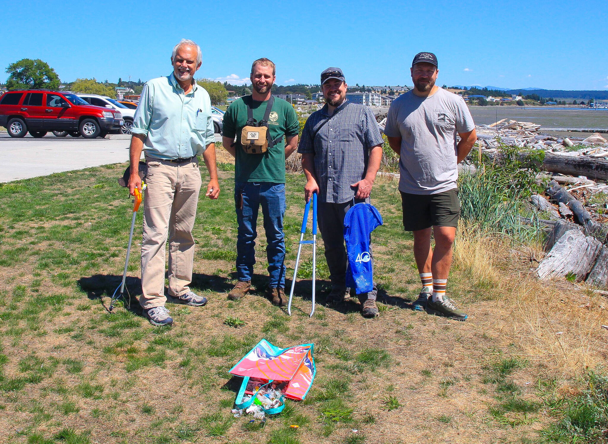 From left, Darwin Christopherson, Washington Department of Fish and Wildlife Biologist Kurt Licence, WDFW Waterfrowl Section Manager Kyle Spragens and Peter Steelquist pose with the wads they collected at Windjammer Park on Aug. 2. (Photo by Luisa Loi/Whidbey News-Times)