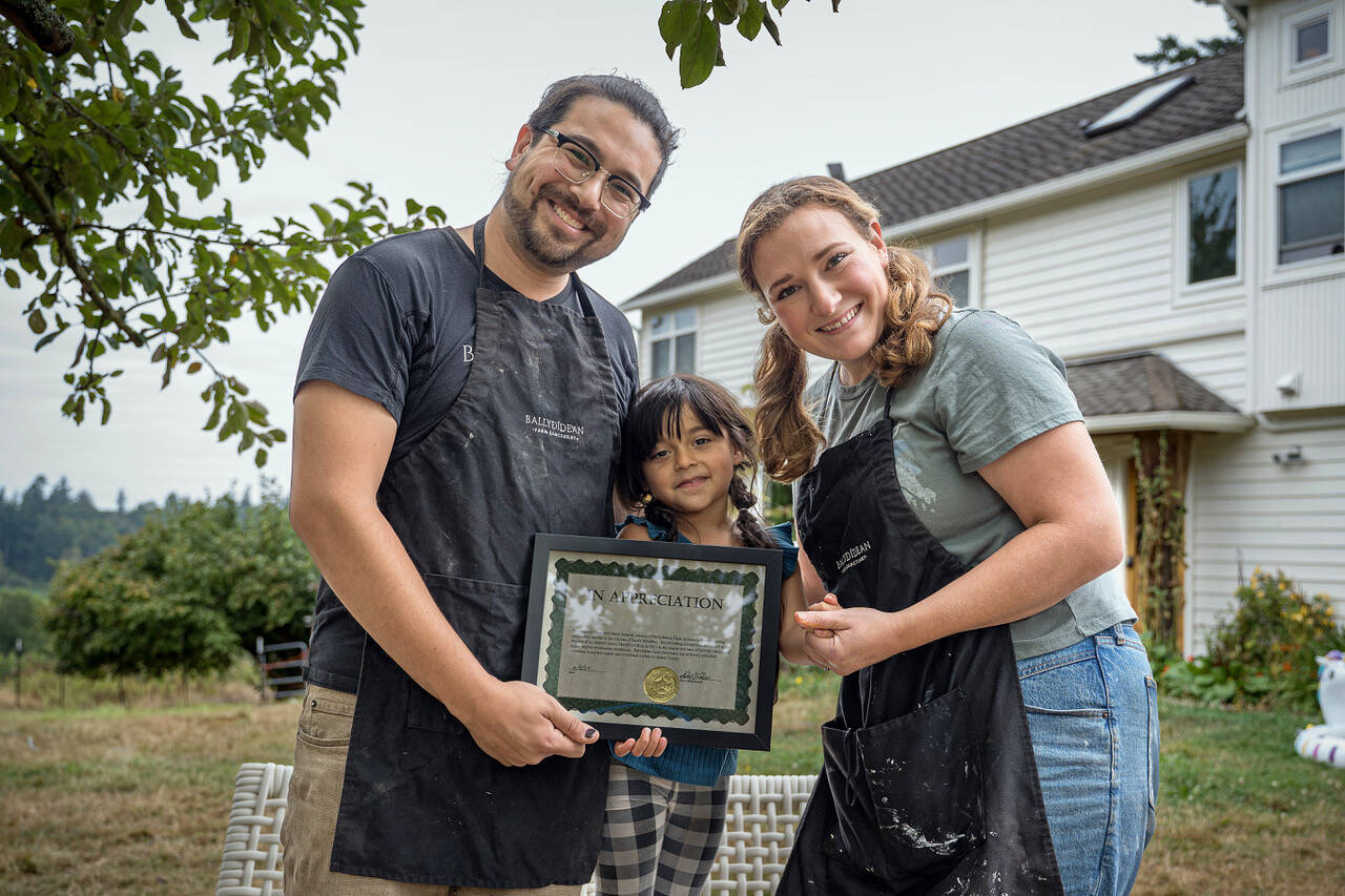 Photo by David Welton From left, Ansel, Gwen and Sarah Santosa hold the award given to Ballydidean Farm Sanctuary by the Island County Sheriff's Office.