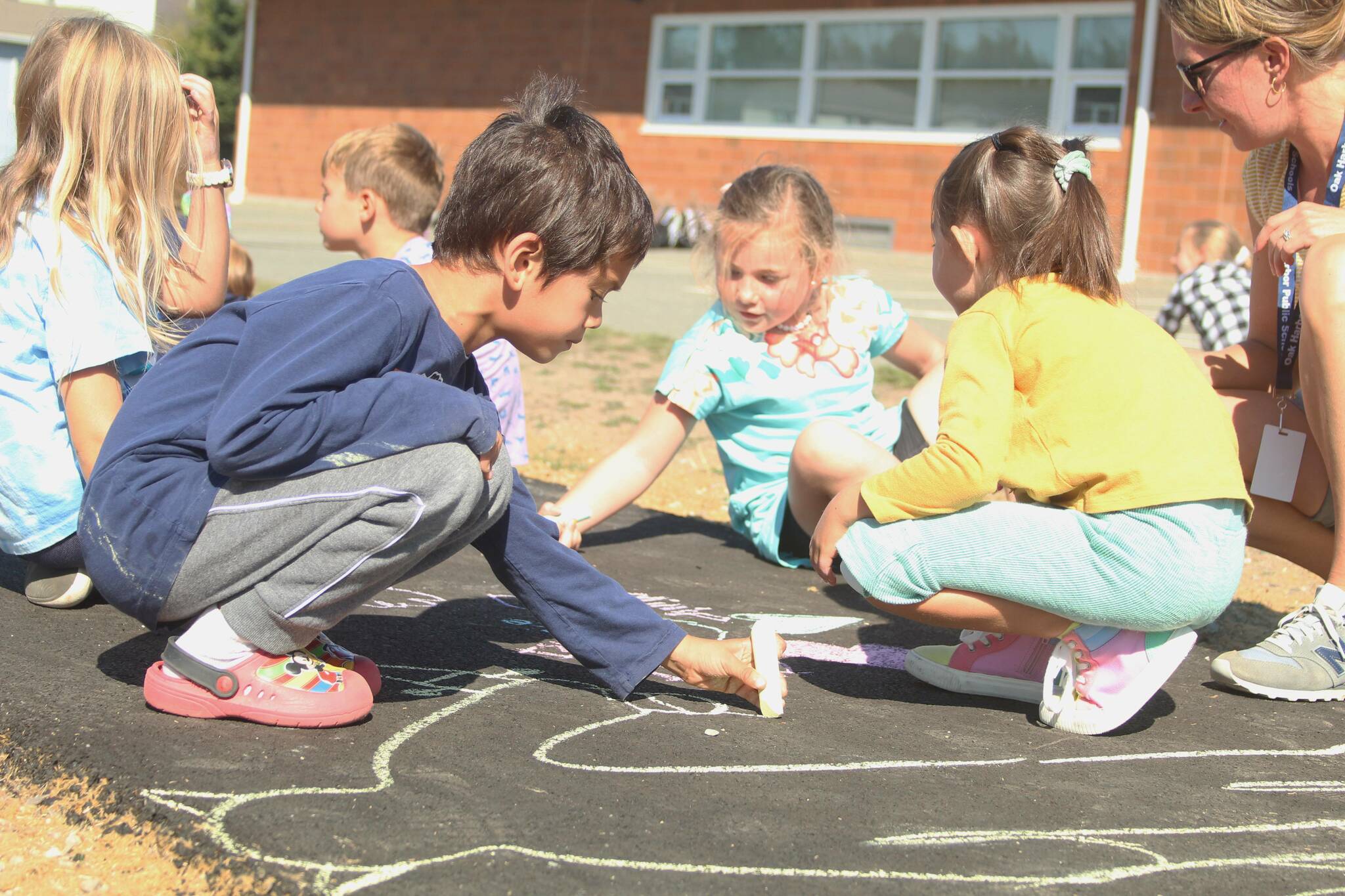 Photo by Karina Andrew/Whidbey News-Times
First grader Ian Kerner helps “chalk the walk” Sept. 15 at Hillcrest Elementary School.