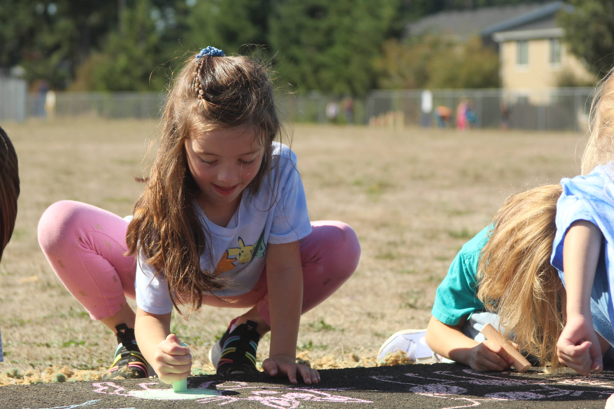 Photo by Karina Andrew/Whidbey News-Times
First grader Madilynn Davenport helps “chalk the walk” Sept. 15 at Hillcrest Elementary School.