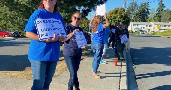 Members of PSE 821 wave signs in support of the union's negotiating team outside of North Whidbey Middle School during a bargaining session Thursday, Sept. 14.