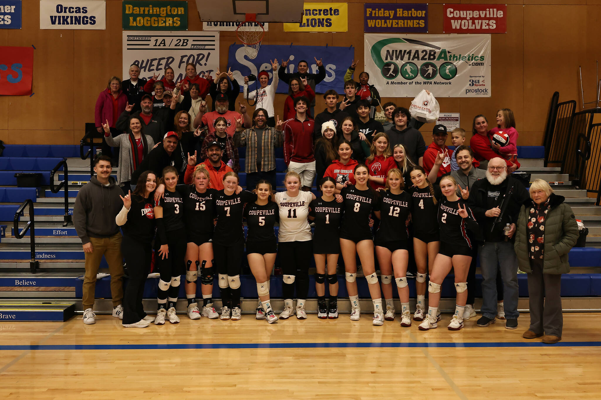 Photo by John Fisken
The Wolf volleyball team poses with their fans after earning their first trip to the state tournament since 2017.