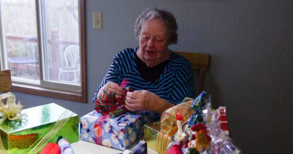 Photo by Luisa Loi
June Zacharia prepares gifts for the Holiday House at her house in Oak Harbor. Every year, she begins to prepare for the event in January, buying gift wrap paper, ribbons and more.