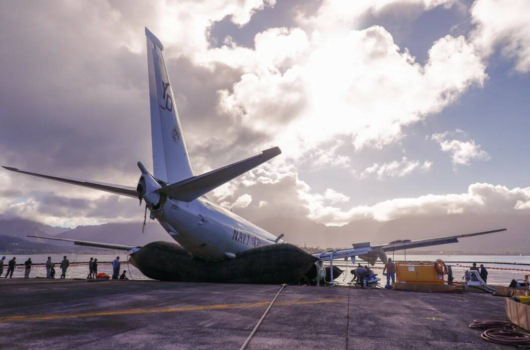 The Navy P8-A Poseidon is removed from the water with the help of inflatable salvage roller bags, placed under the aircraft. (Photo by Lance Cpl. Hunter Jones)