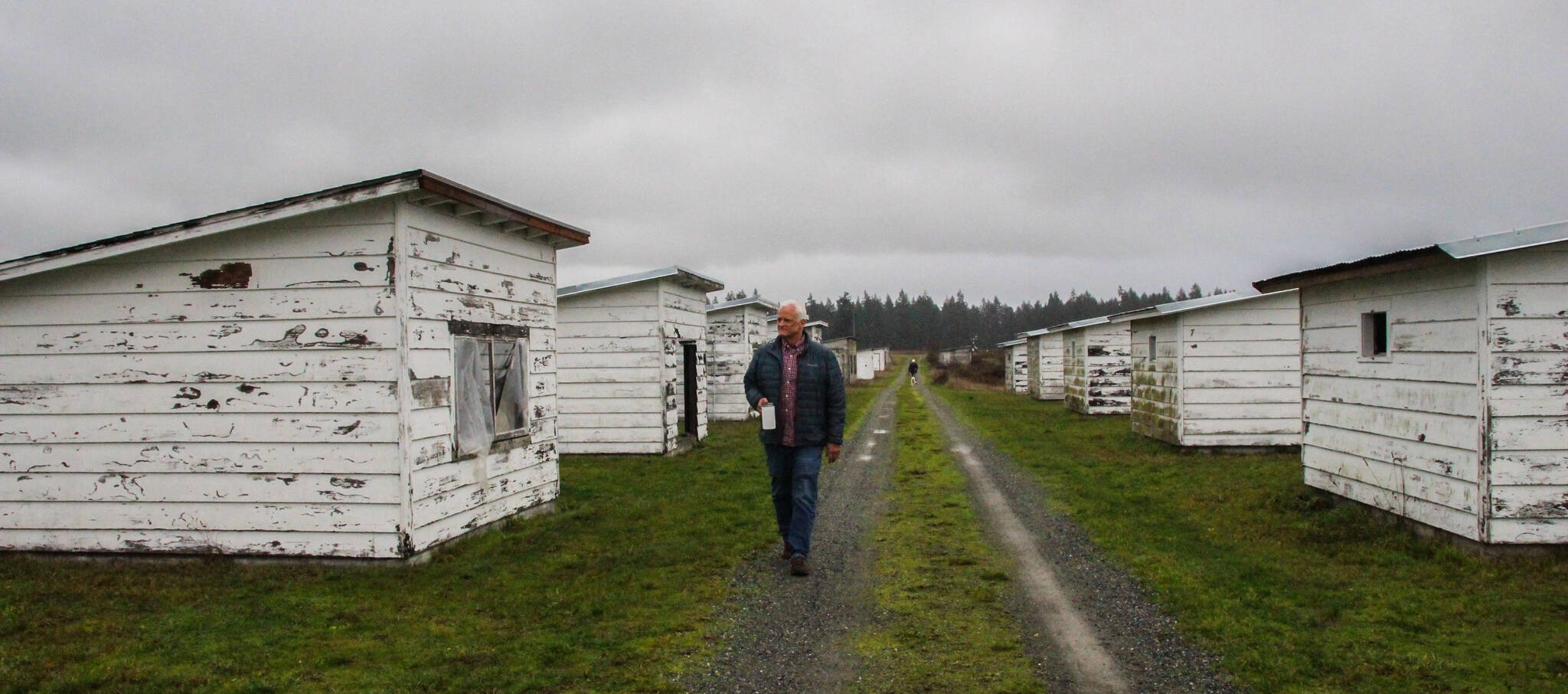 Robert Pelant walks by the former brooder houses for pheasant chicks. (Photo by Luisa Loi)