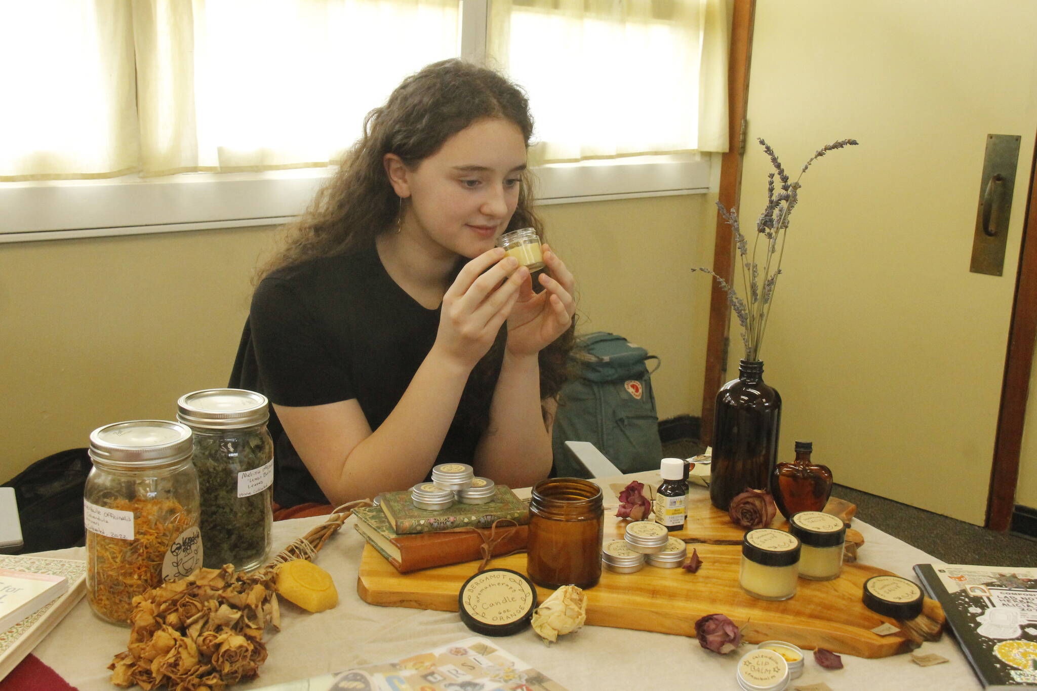 Tenth grader Alicia Jenkins smells some lemon balm lip balm she made. (Photo by Kira Erickson/South Whidbey Record)