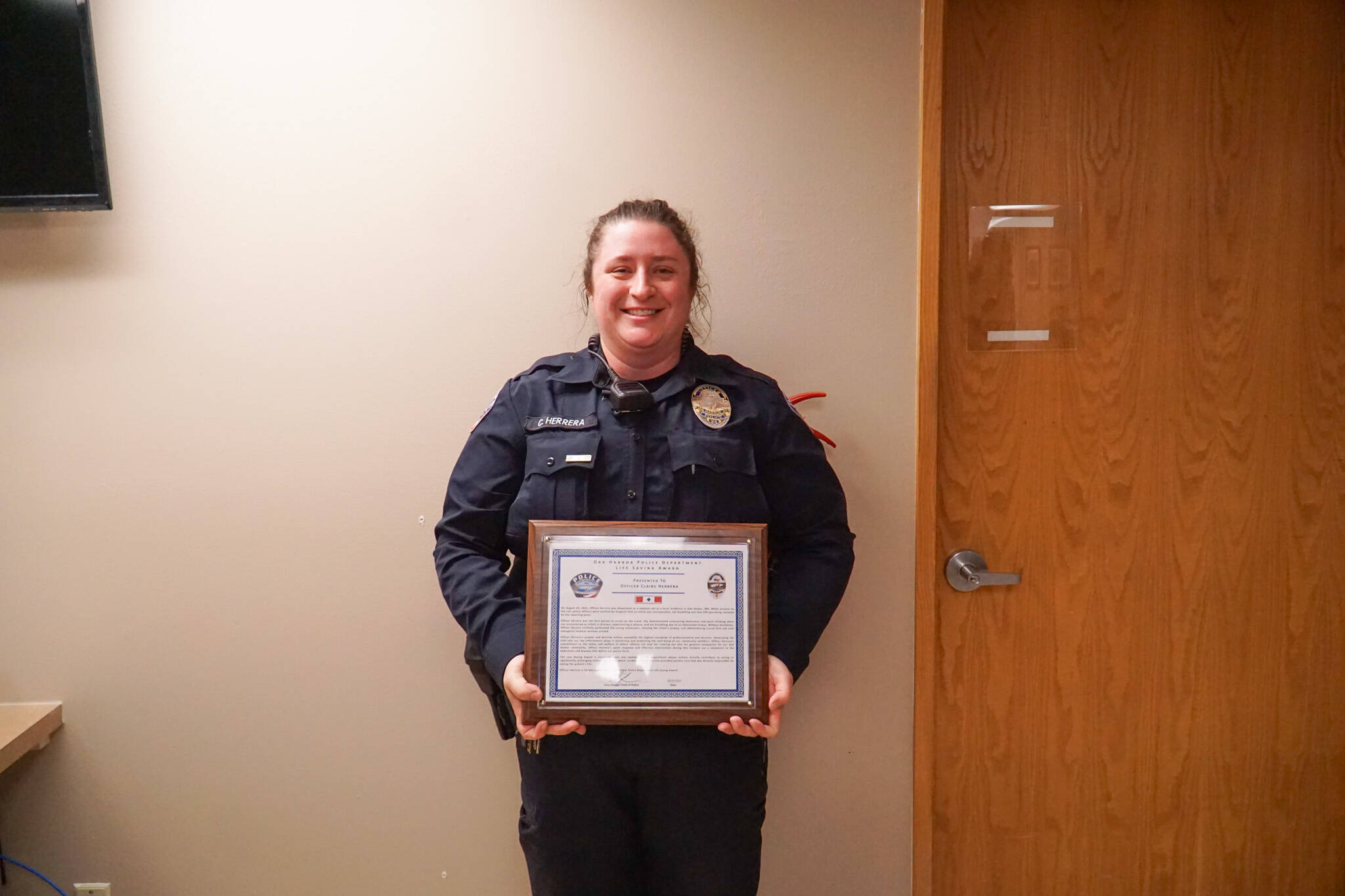 Officer Claire Herrera displays the life saving award, which she received on Monday from the Oak Harbor Police Department. (Photo by Sam Fletcher)