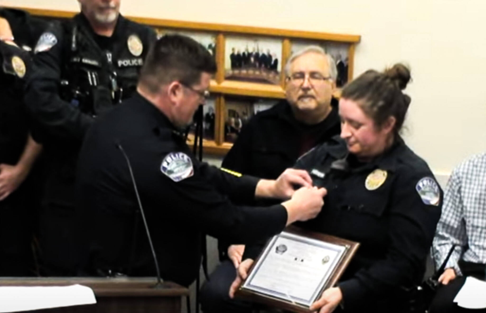 Oak Harbor Police Chief Tony Slowik (left) pins a commendation bar on Officer Claire Herrera's uniform for saving a child's life. (Photo courtesy of the City of Oak Harbor)