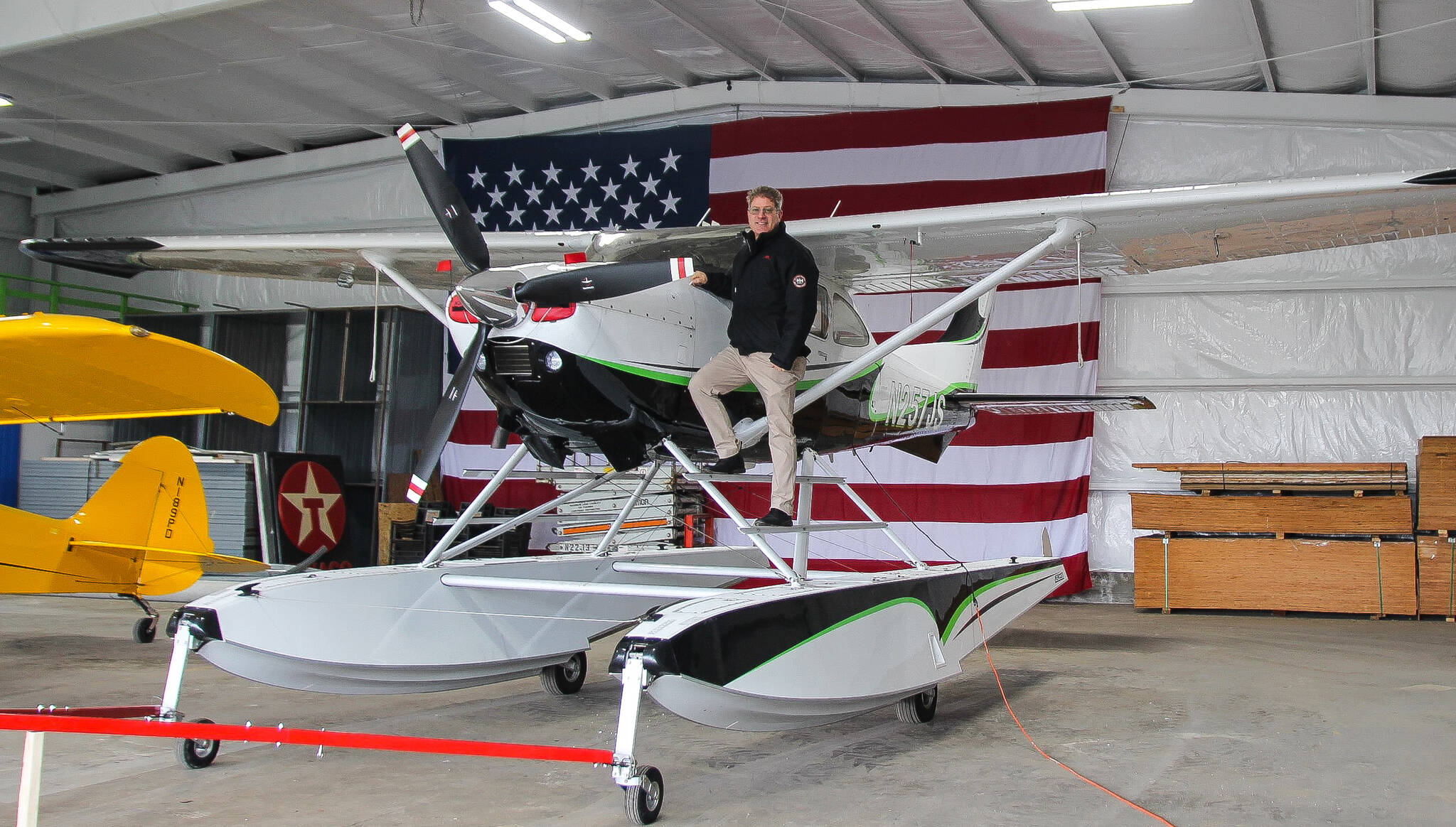 Photo by Luisa Loi
Robert DeLaurentis poses next to his Cessna 182 on aerocet amphibious floats, which is parked inside of the airport’s main hangar. DeLaurentis also hung a 20-by-30-foot American flag on the wall of the building, which will become an air and car museum and potentially a convention center for community events.