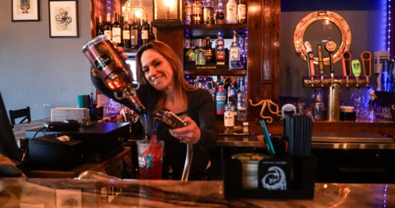 Megan Collins, co-owner of Kraken's Cove in Oak Harbor, pours a drink at the bar.  (Photo by Sam Fletcher)