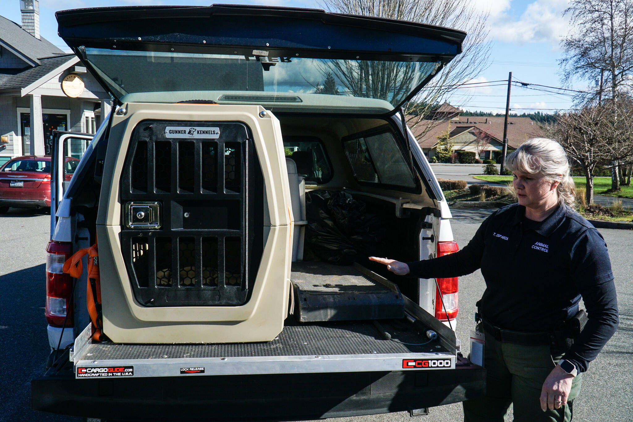 Whidbey Island animal control officer Tammy Esparza displays a kennel from the back of the animal control pick-up. (Photo by Sam Fletcher)