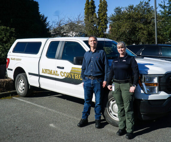 Island County's new animal control officers, Dylan Shipley (left) and Tammy Esparza (right) pose in front of the animal control pick-up. (Photo by Sam Fletcher)
