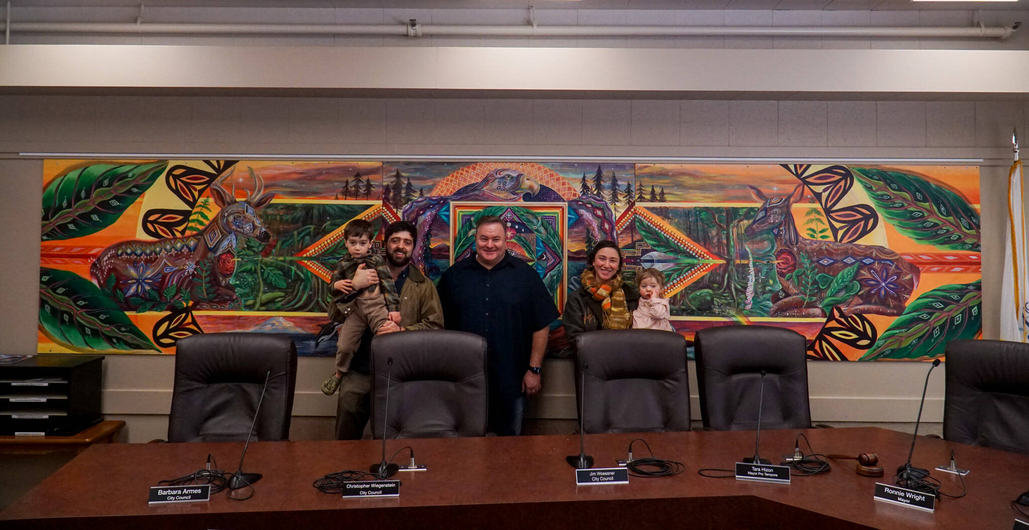 From left to right: George Mann, artist Nick Mann, Mayor Ronnie Wright, artist Kendall Mann and Anastasia Mann pose before the newly-installed “Song of the Salish Sea” in council chambers. (Photo by Sam Fletcher)