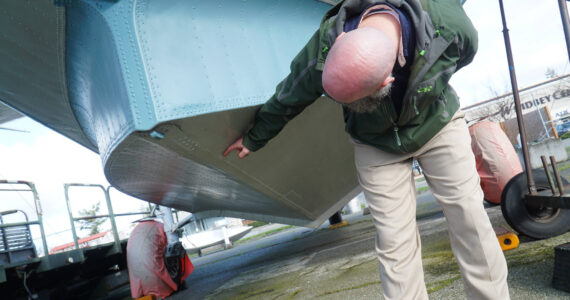 Andrew Cummings, PNW Naval Air Museum aircraft conservation and restoration lead, identifies punctures in the PBY that need to be repaired. (Photo by Sam Fletcher)