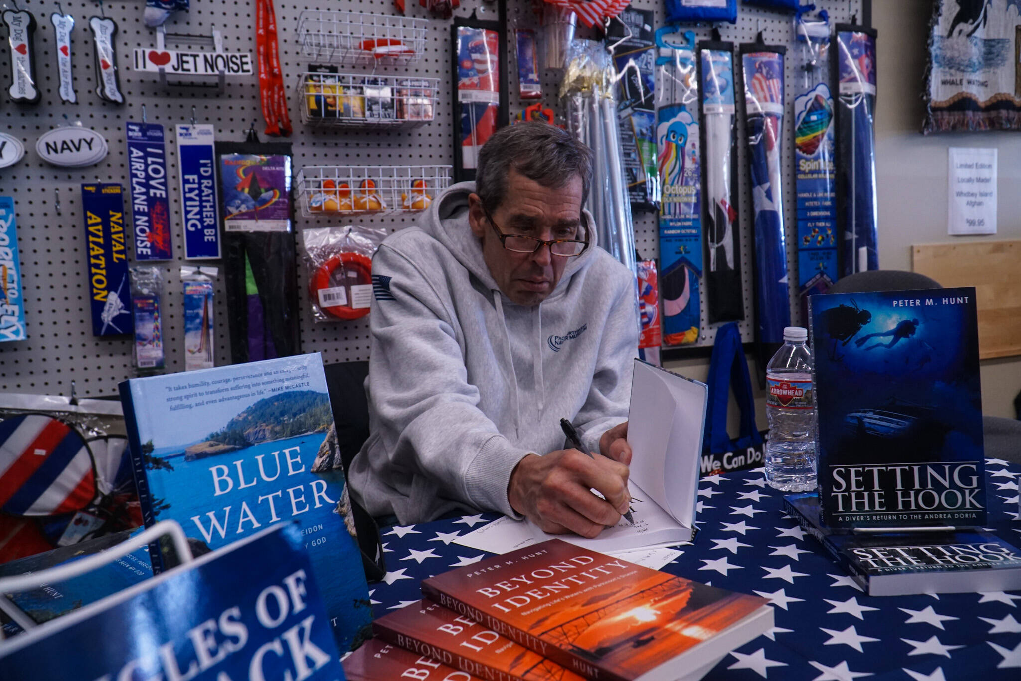Whidbey author Peter Hunt signing his latest book, Blue Water, at the Pacific Northwest Naval Air Museum on Thursday (Photo by Sam Fletcher)