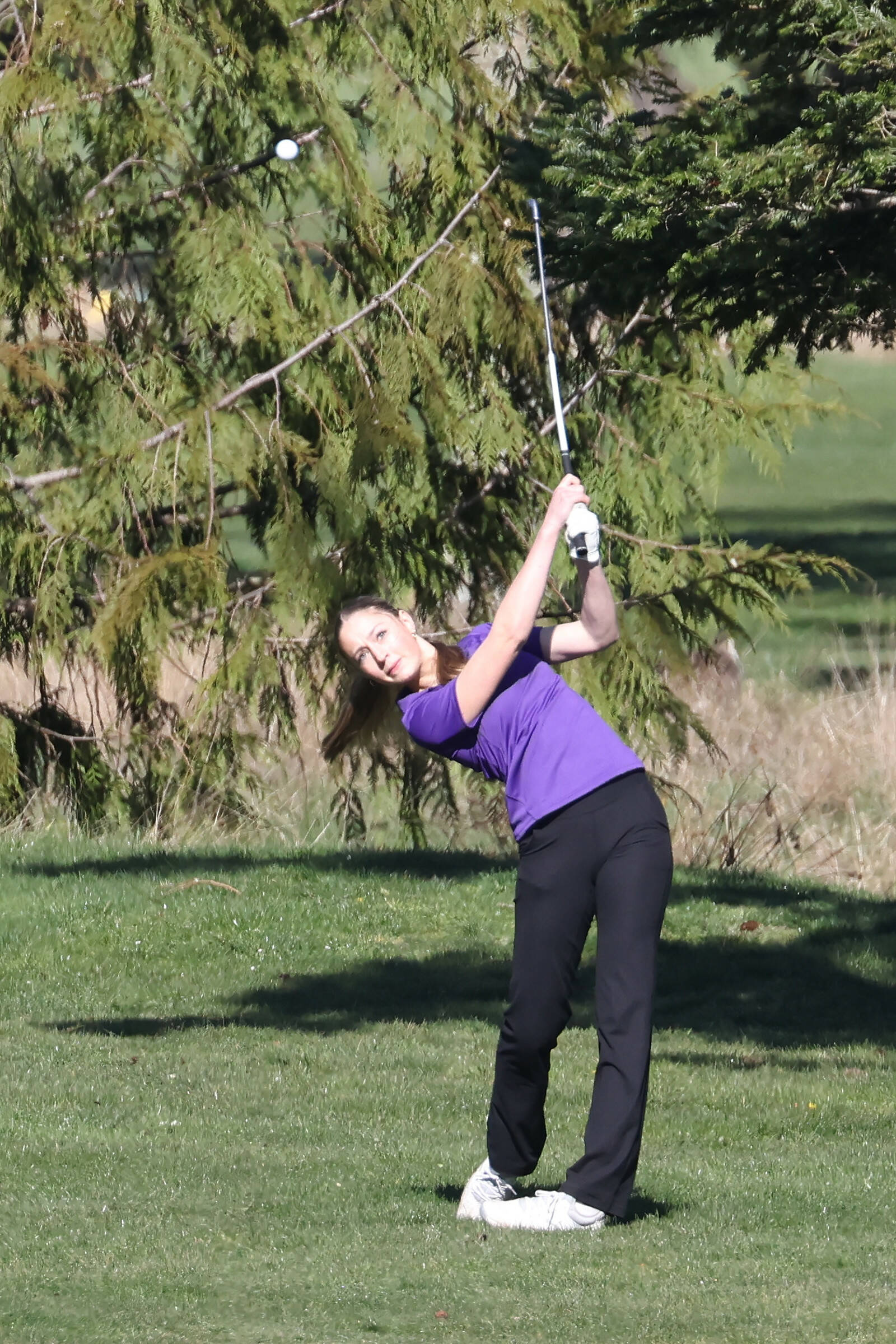 Oak Harbor girls golfer Addison Nations hits the ball during the Whidbey Shootout where the Wildcats competed against 15 other teams March 18 at the Whidbey Golf Club. Nations tied for seventh hitting 13-over-par 85. (Photo by John Fisken)