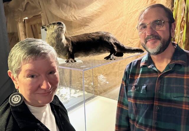 Dalva Church and Rick Castellano stand with an otter.